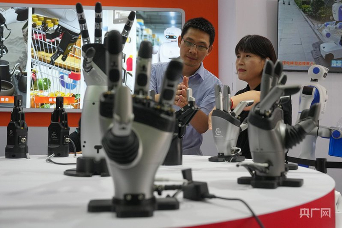 2026年8月19日，北京，观众在北人亦创国际会展中心举办的世界机器人大会上观看展出的机器人手。